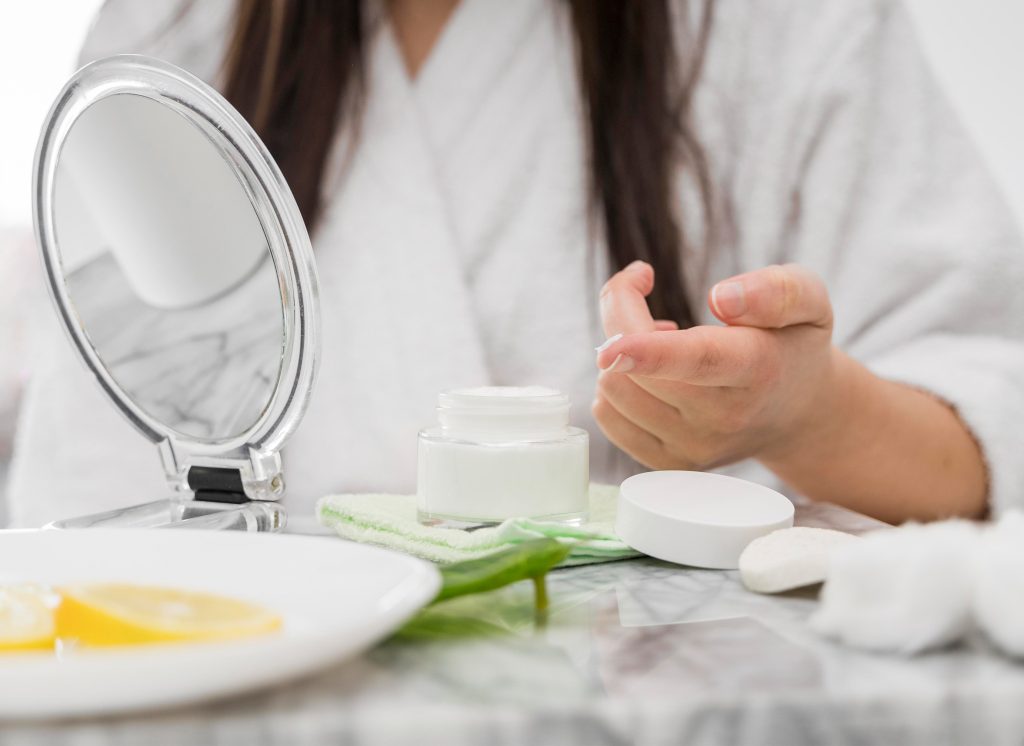 women in front of mirror doing skincare routing skincare line, Laboratoire cosmétique Maroc