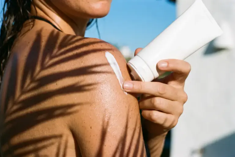 Femme appliquant une crème solaire en marque blanche