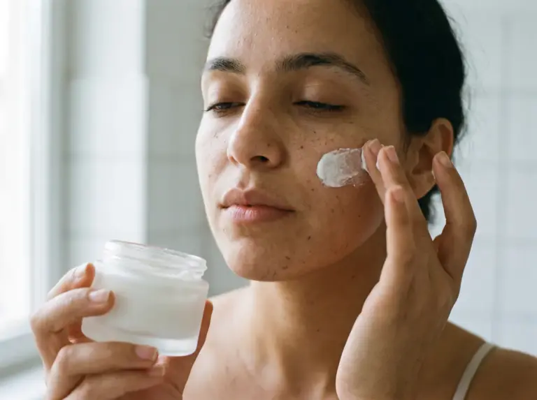 Femme appliquant une crème visage en marque blanche