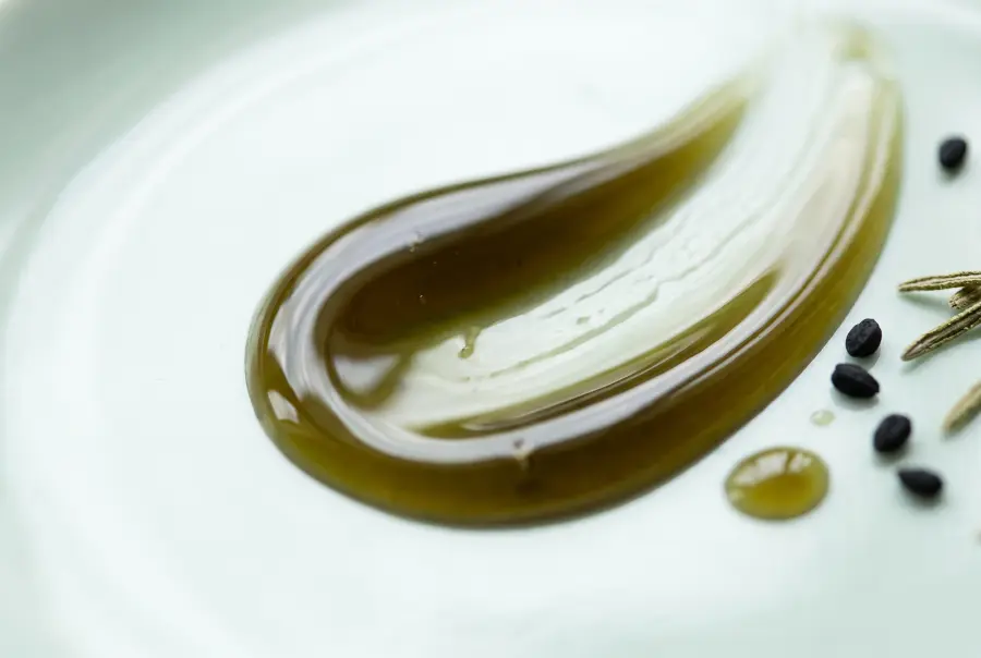Texture huile capillaire romarin et nigelle en gros plan