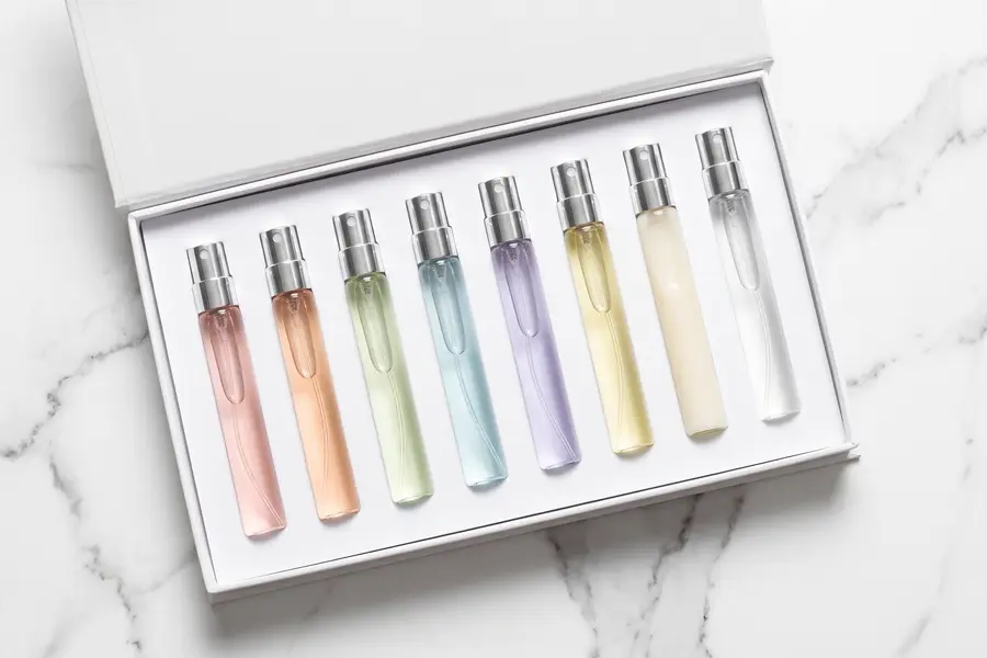 Textura del perfume en formato de viaje y estuche en primer plano